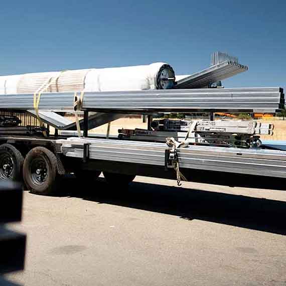 Metal carport being delivered on the back of a truck